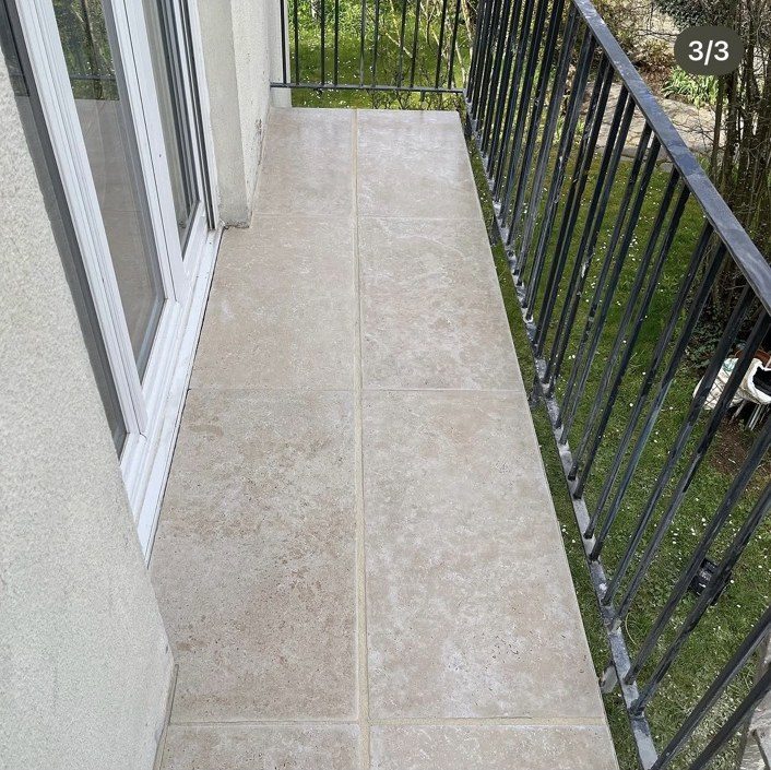 Balcon après travaux : grandes dalles claires posées à joints fins